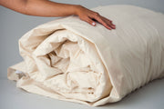 Organic cotton duvet cover in natural color rolled up with insert.