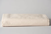 Organic cotton crib sheets in natural color folded.